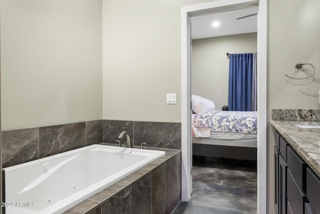 bathroom with tiled tub and vanity