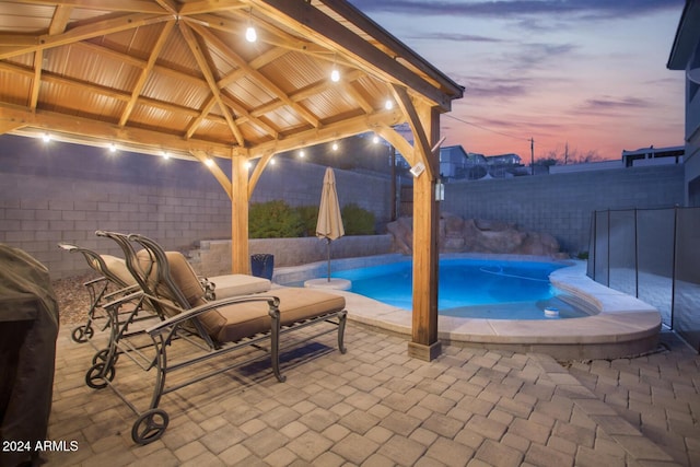 pool at dusk with a gazebo