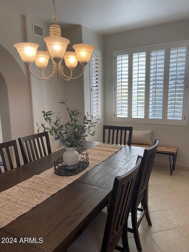 dining space featuring a notable chandelier and light tile floors