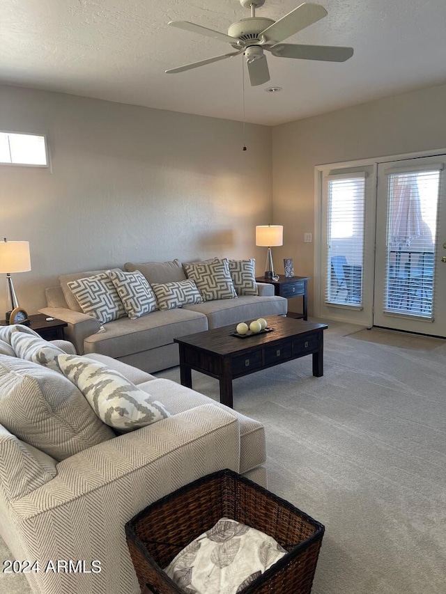 carpeted living room with ceiling fan and a textured ceiling