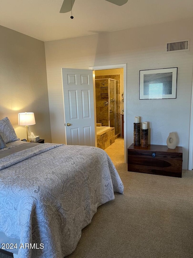 carpeted bedroom with ensuite bath and ceiling fan