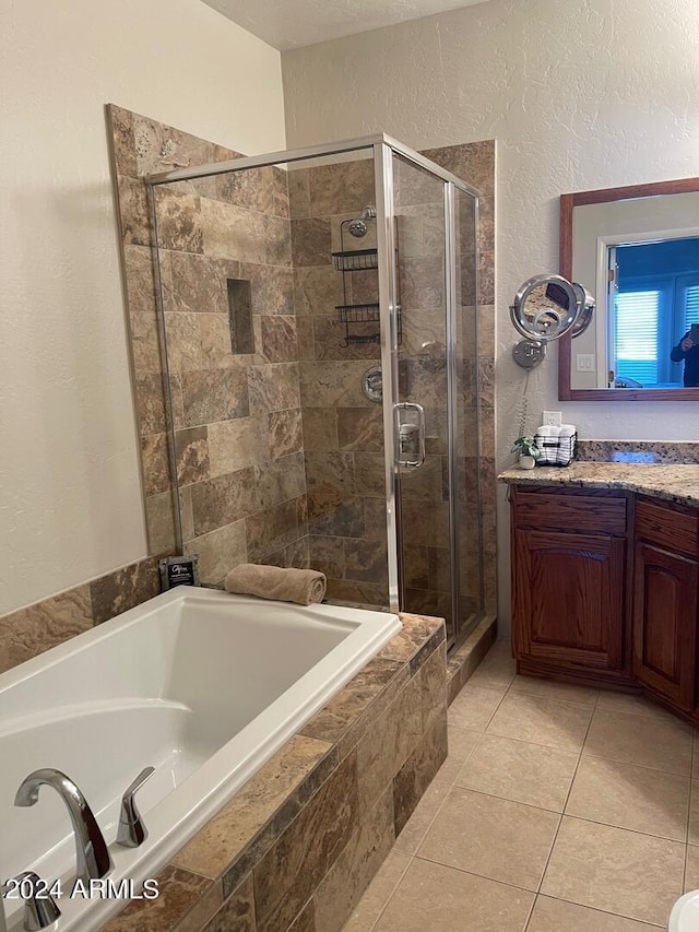 bathroom with plus walk in shower, tile floors, and vanity with extensive cabinet space