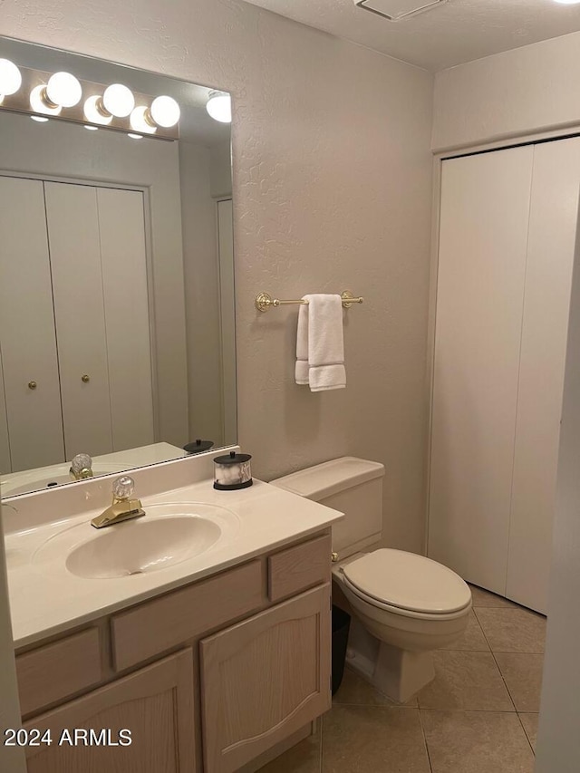 bathroom with vanity, tile flooring, and toilet