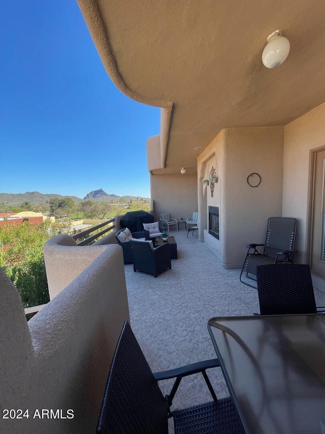 view of terrace featuring a balcony, an outdoor hangout area, and a mountain view