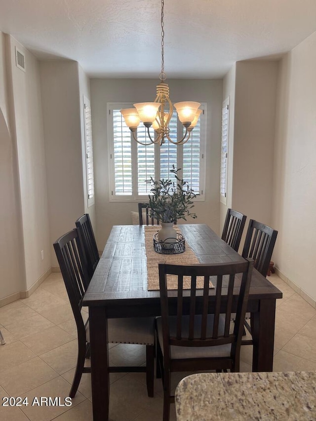 tiled dining area featuring an inviting chandelier