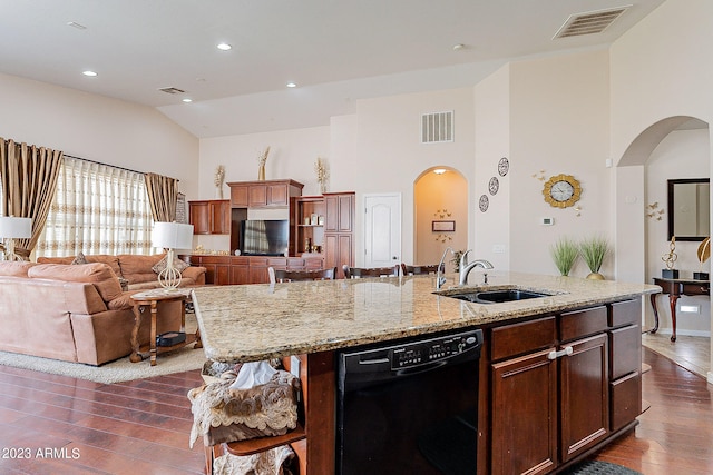 kitchen featuring light stone countertops, sink, a center island with sink, black dishwasher, and dark hardwood / wood-style floors