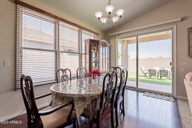 dining room featuring dark hardwood / wood-style flooring, vaulted ceiling, a wealth of natural light, and a notable chandelier