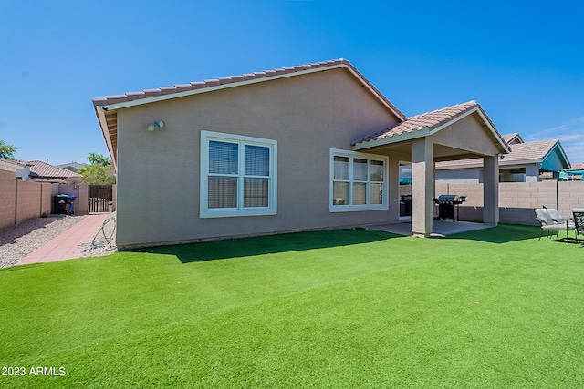 rear view of house with a yard and a patio