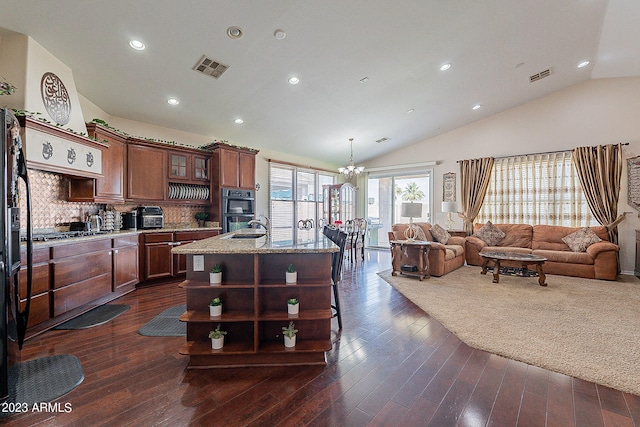 kitchen with multiple ovens, tasteful backsplash, vaulted ceiling, and dark wood-type flooring