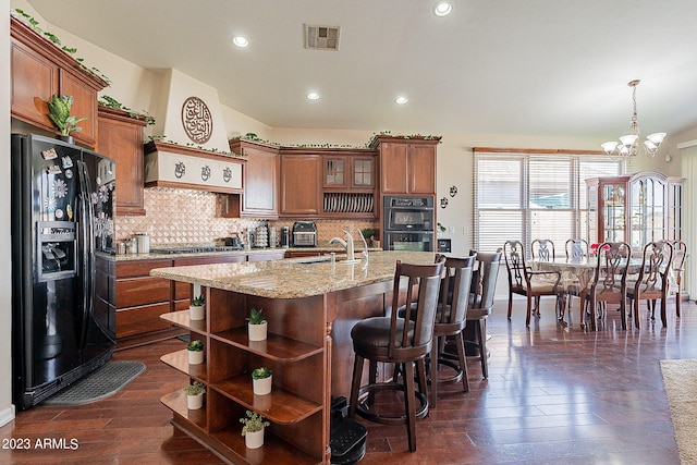 kitchen with tasteful backsplash, black appliances, a chandelier, dark hardwood / wood-style floors, and hanging light fixtures