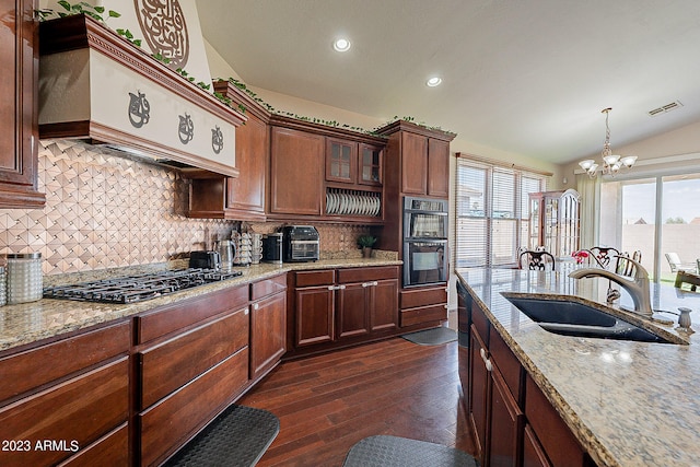 kitchen with dark hardwood / wood-style flooring, a notable chandelier, pendant lighting, lofted ceiling, and stainless steel gas stovetop