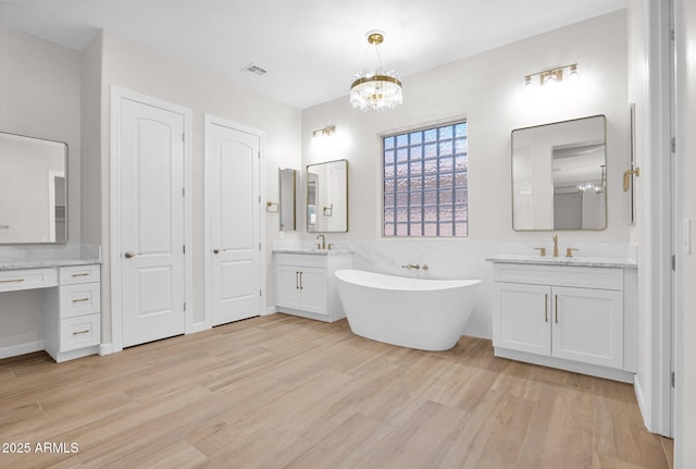 20115 E Sonoqui Blvd E, Queen Creek, AZ 85142 - full bath featuring wood finished floors, a chandelier, a freestanding bath, and two vanities