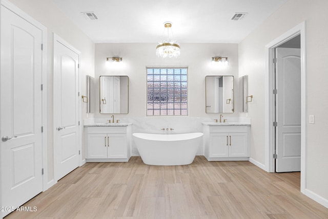 20115 E Sonoqui Blvd E, Queen Creek, AZ 85142 - full bathroom with wood finished floors, a freestanding tub, two vanities, and a chandelier