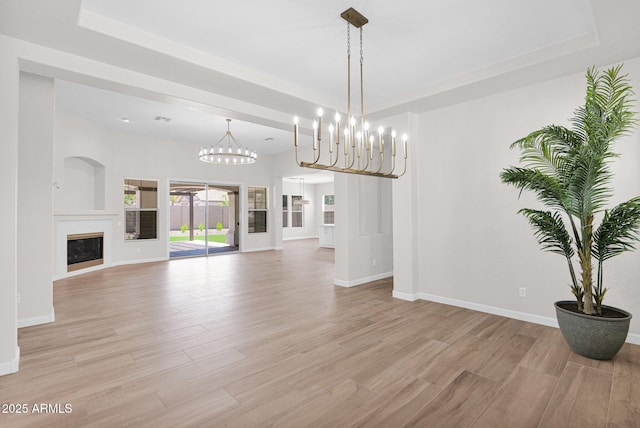20115 E Sonoqui Blvd E, Queen Creek, AZ 85142 - unfurnished living room with light wood-style floors, a raised ceiling, a chandelier, and a fireplace