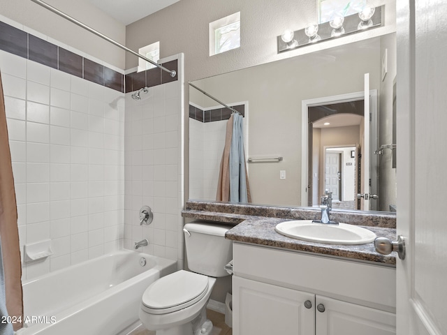 full bathroom featuring toilet, vanity, and shower / tub combo with curtain