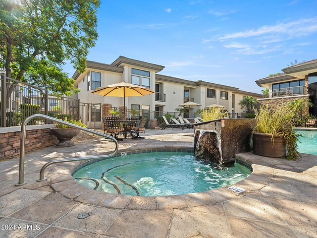 view of swimming pool with a community hot tub and a patio area