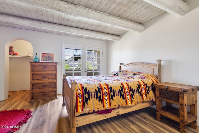 bedroom featuring beamed ceiling, wood-type flooring, and wooden ceiling