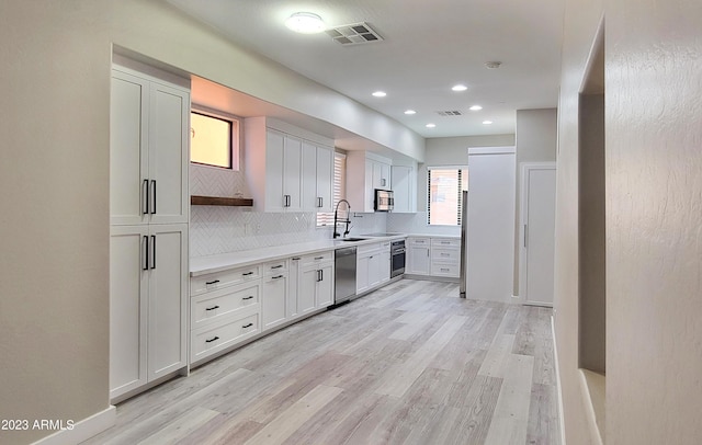 9551 E Redfield Rd Unit 1061, Scottsdale, AZ 85260 - kitchen featuring stainless steel appliances, tasteful backsplash, light countertops, a sink, and light wood-type flooring