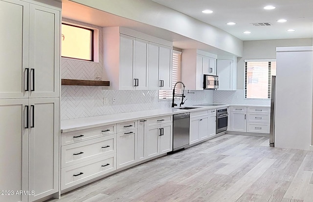 9551 E Redfield Rd Unit 1061, Scottsdale, AZ 85260 - kitchen featuring stainless steel appliances, a sink, light countertops, light wood-type flooring, and tasteful backsplash