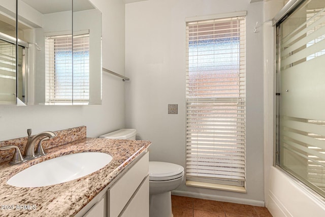 full bathroom with toilet, a wealth of natural light, tile patterned floors, and shower / bath combination with glass door