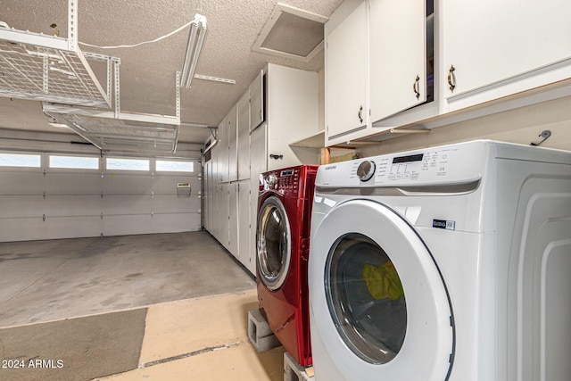 laundry room featuring cabinets, washing machine and dryer, and a textured ceiling