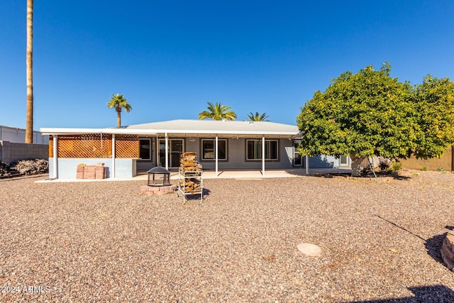 back of property with an outdoor fire pit