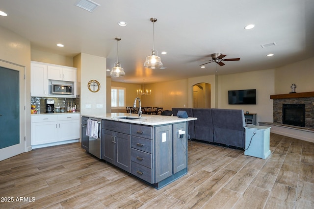 kitchen featuring a sink, white cabinetry, appliances with stainless steel finishes, visible vents, and arched walkways