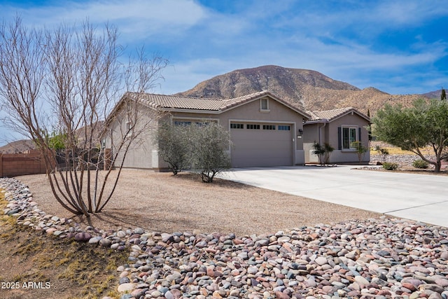 ranch-style house with a tiled roof, stucco siding, driveway, and a garage