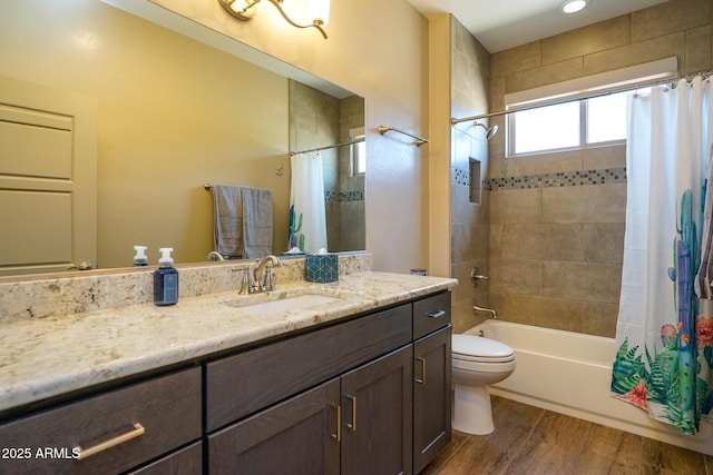 bathroom featuring toilet, vanity, shower / tub combo with curtain, and wood finished floors