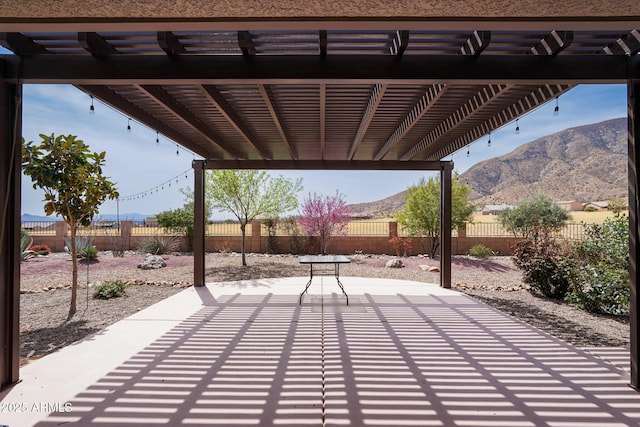view of patio featuring a pergola, a fenced backyard, and a mountain view