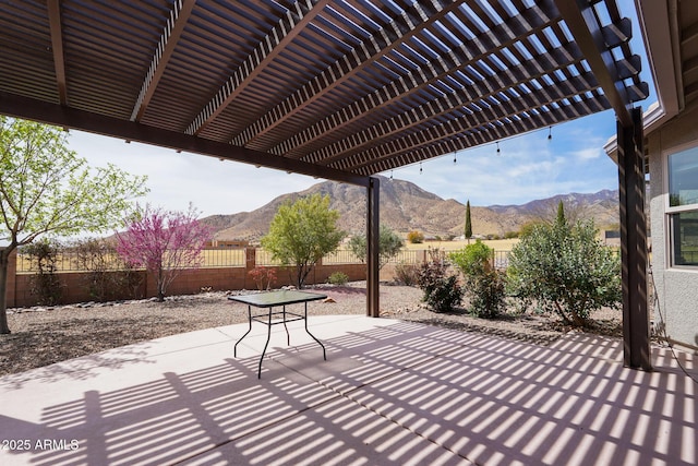 view of patio / terrace featuring a fenced backyard, a pergola, and a mountain view