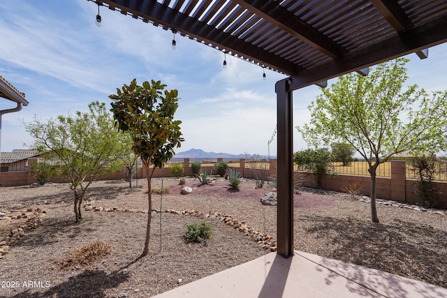 view of yard featuring a patio, a mountain view, a fenced backyard, and a pergola