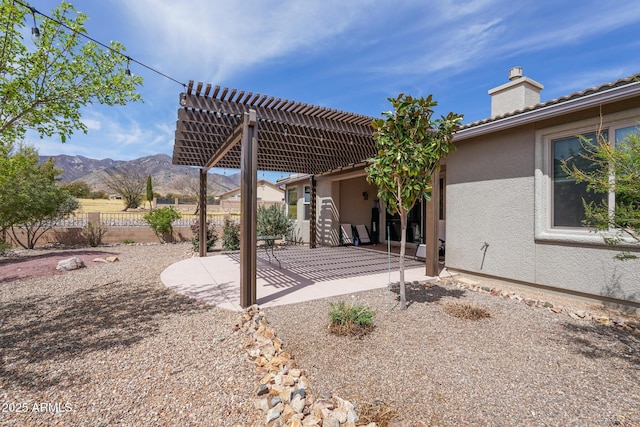 view of patio / terrace featuring a pergola, a mountain view, and fence