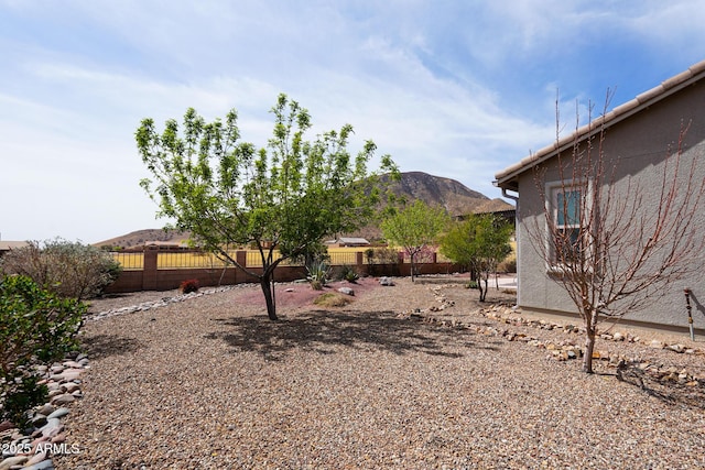 view of yard featuring fence and a mountain view