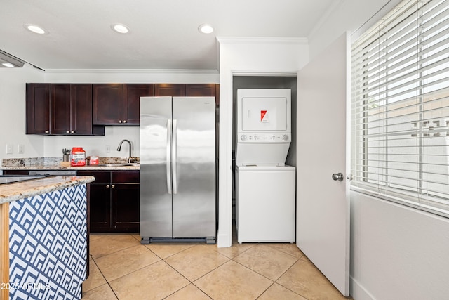 8315 E Devonshire Ave, Scottsdale, AZ 85251 - kitchen with freestanding refrigerator, stacked washer / dryer, light tile patterned floors, ornamental molding, and light stone counters