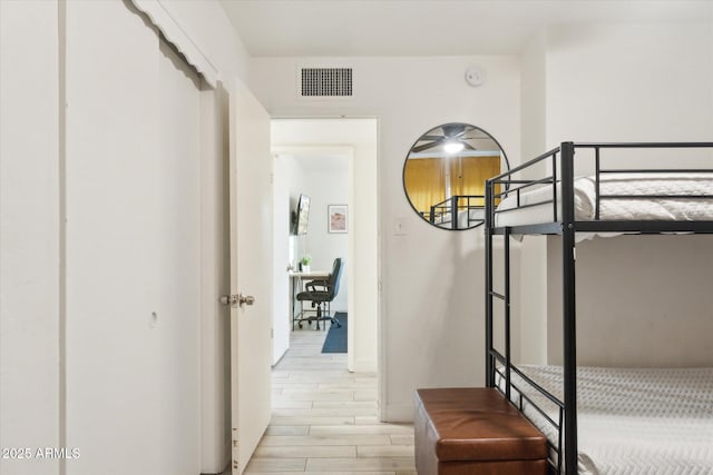 hallway featuring visible vents, baseboards, and wood tiled floor