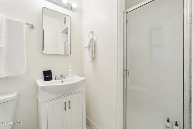 bathroom with vanity, a shower stall, and toilet