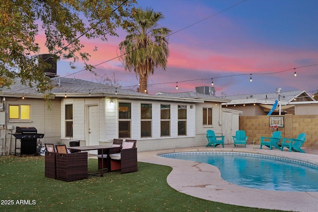 back of house with a patio area, a lawn, a fenced in pool, and fence