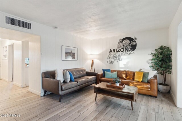 living area featuring baseboards, visible vents, and light wood-type flooring