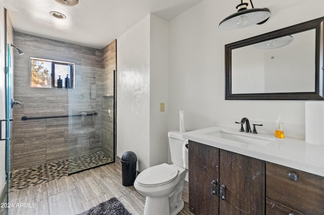 bathroom with vanity, toilet, a shower with shower door, and wood-type flooring