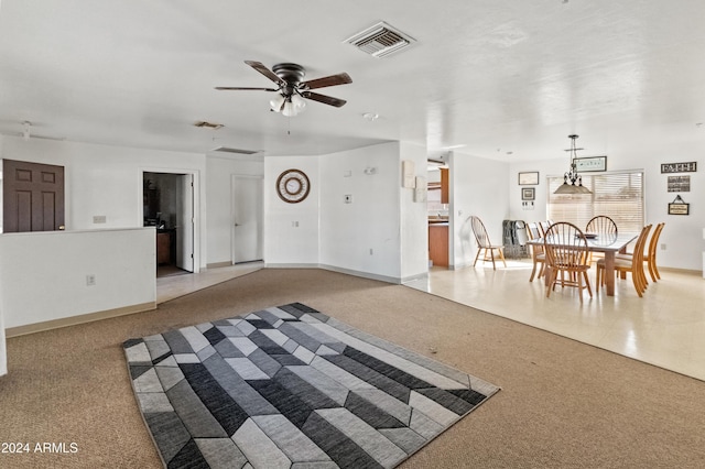 unfurnished living room featuring ceiling fan and light colored carpet