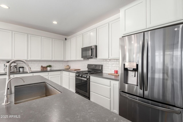 kitchen featuring stainless steel refrigerator with ice dispenser, sink, white cabinets, and black range with gas stovetop