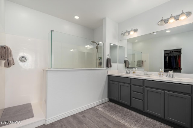 bathroom featuring hardwood / wood-style flooring, a shower, and vanity