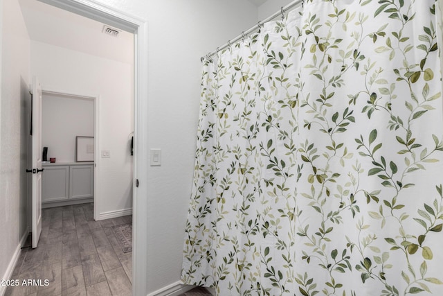 bathroom featuring hardwood / wood-style floors and walk in shower