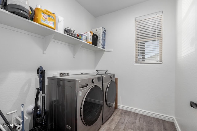 laundry room with independent washer and dryer and light hardwood / wood-style flooring