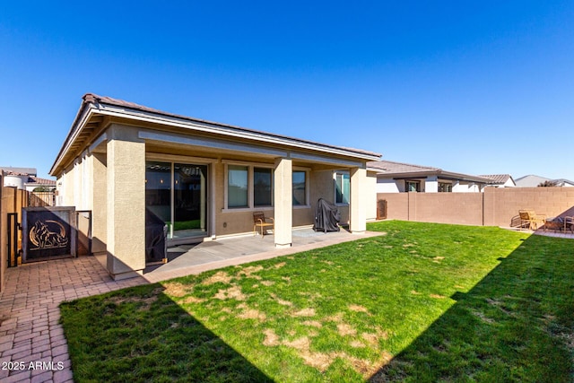 rear view of property featuring a patio area and a yard