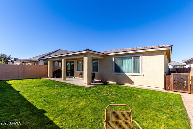 rear view of property featuring a yard and a patio