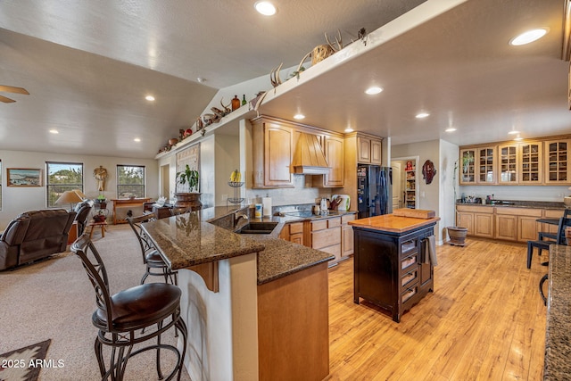 8870 Happy Trl, Show Low, AZ 85901 - kitchen featuring black appliances, dark stone counters, a kitchen breakfast bar, glass insert cabinets, and a peninsula