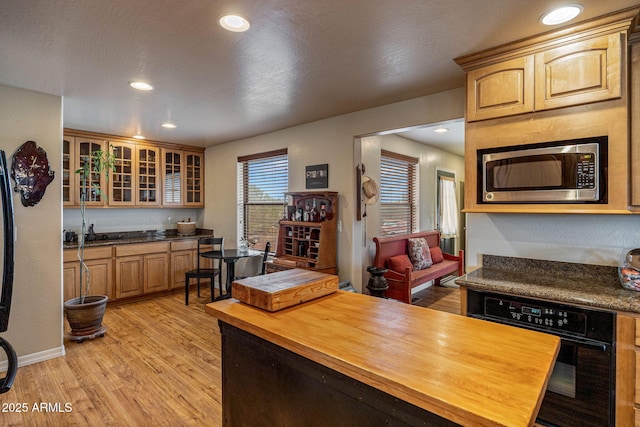 8870 Happy Trl, Show Low, AZ 85901 - kitchen featuring stainless steel microwave, wooden counters, oven, light wood-style floors, and glass insert cabinets