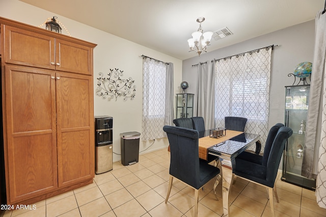 dining room with light tile patterned floors and an inviting chandelier